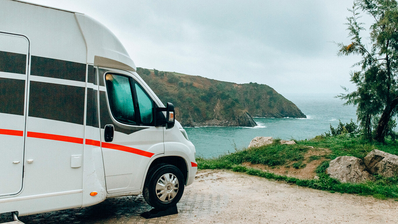 Camping-car blanc stationné face à la mer sur une côte rocheuse en France