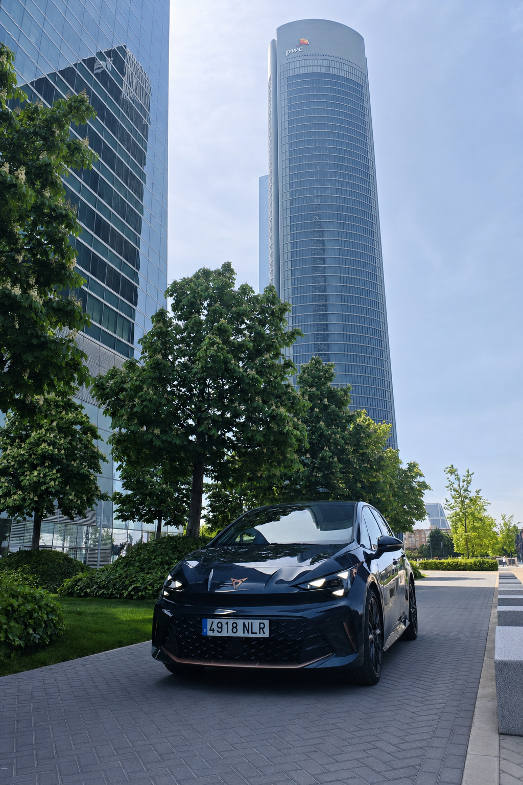 CUPRA Born VZ électrique noire de 326 ch devant des tours de bureaux en ville