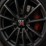 Gros plan sur une jante sport en alliage avec cache-moyeu GT-R et étrier de frein rouge, style racing haute performance