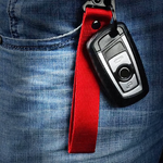 Porte-clés en tissu rouge avec mousqueton, accroché à un pantalon en jean