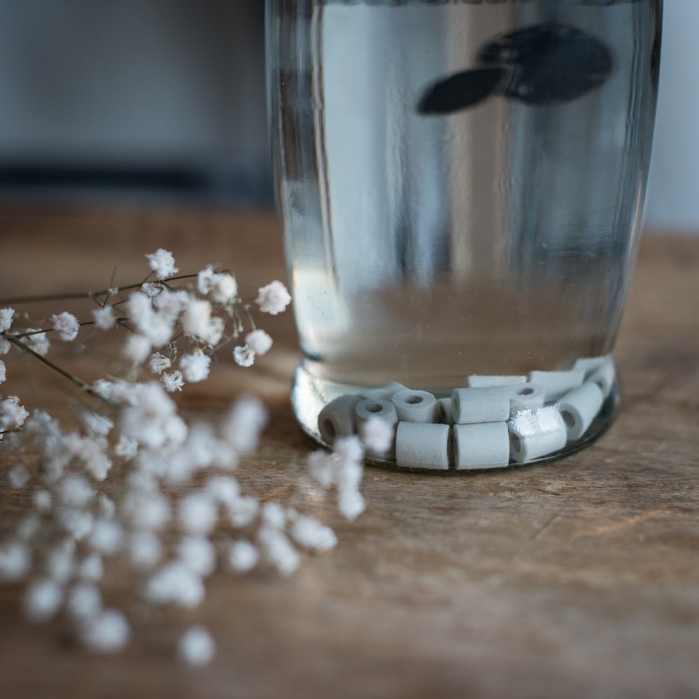 perles en céramique au fond dune carafe deau