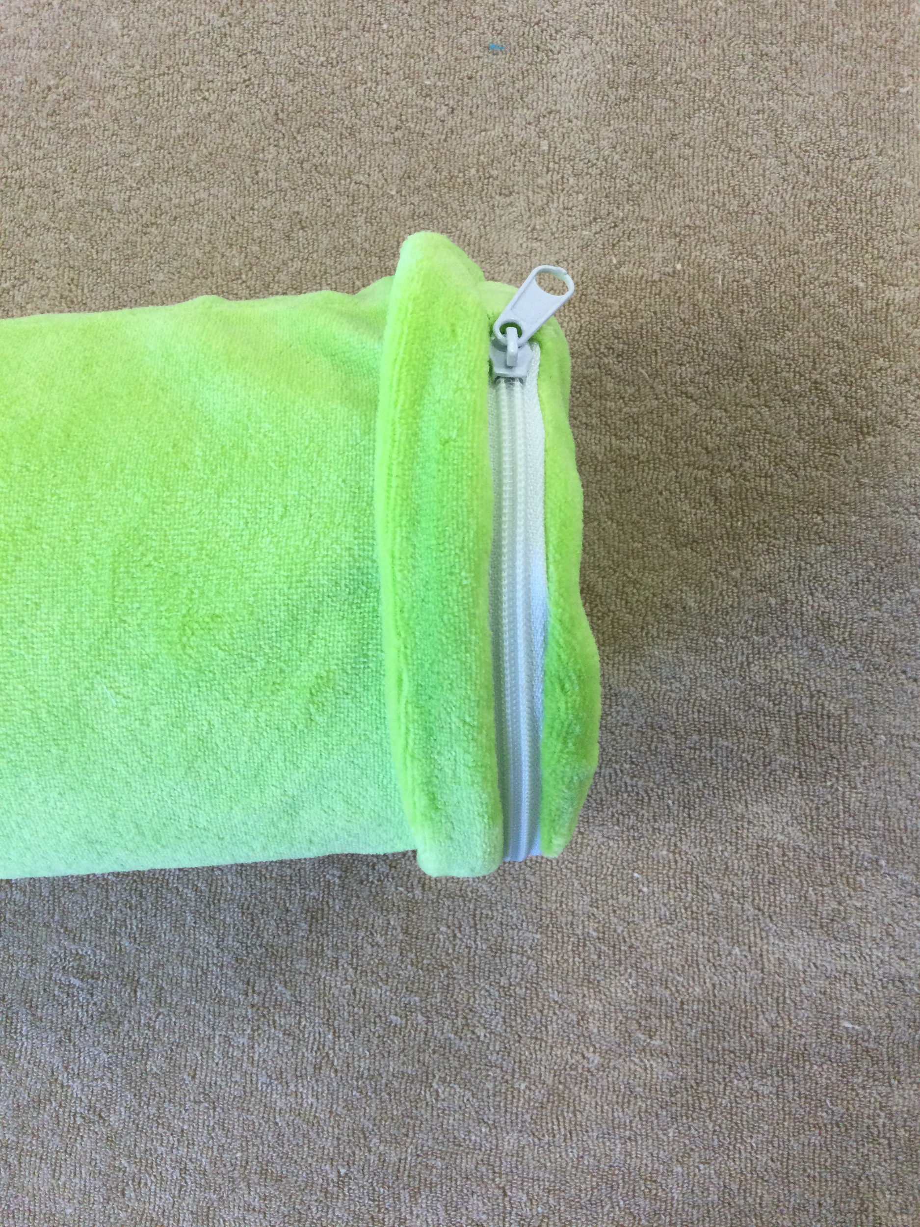 coussin cylindrique flexible en mousse à mémoire de forme vert anis détail de la fermeture diamètre 9 cm vue allongé rabat de la fermeture éclair