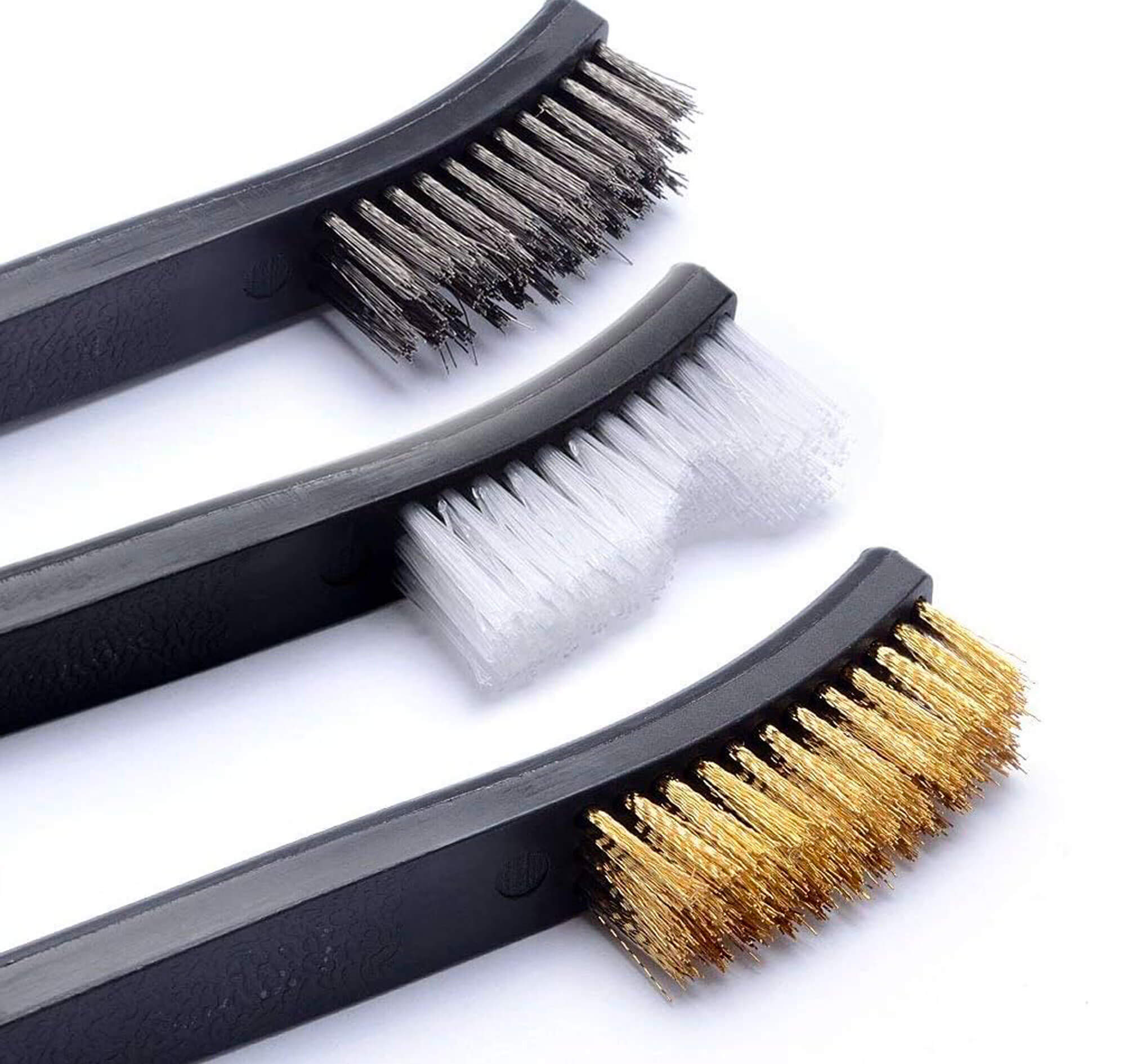 Gros plan sur les têtes de trois brosses : poils gris, blancs et dorés