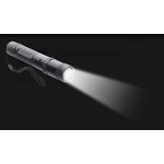 Lampe shocker X6 allumée sur fond noir, faisceau blanc dirigé vers la droite