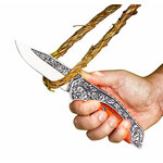 Couteau vintage tenu en main, la lame engagée dans une boucle de cordage