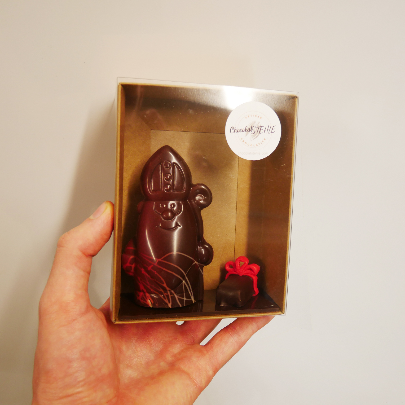 Saint-nicolas en chocolat noir tenu en main chocolatstehle