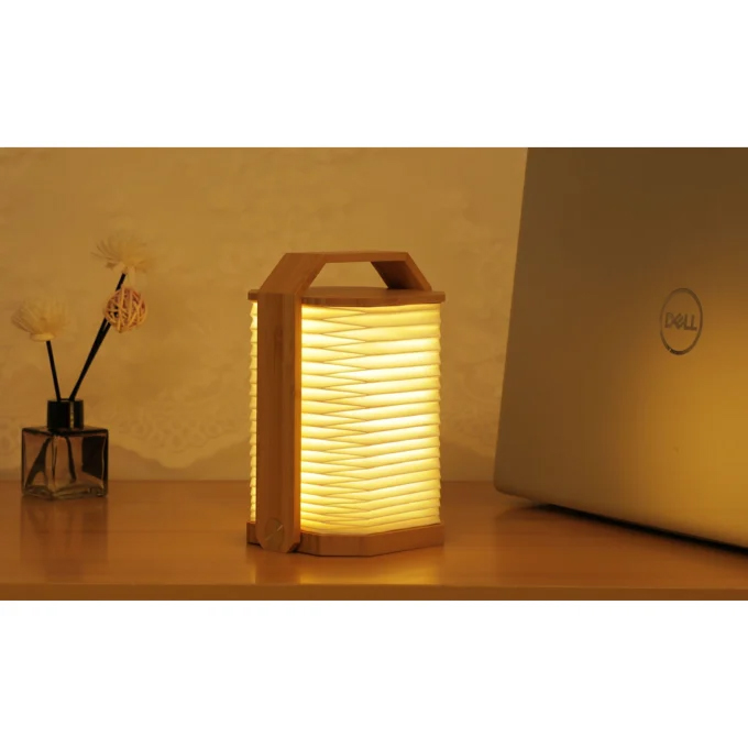 Lampe accordéon à côté dun ordinateur