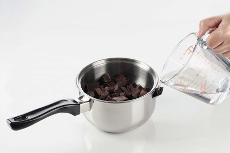De leau versée dans une casserole remplie de chocolat