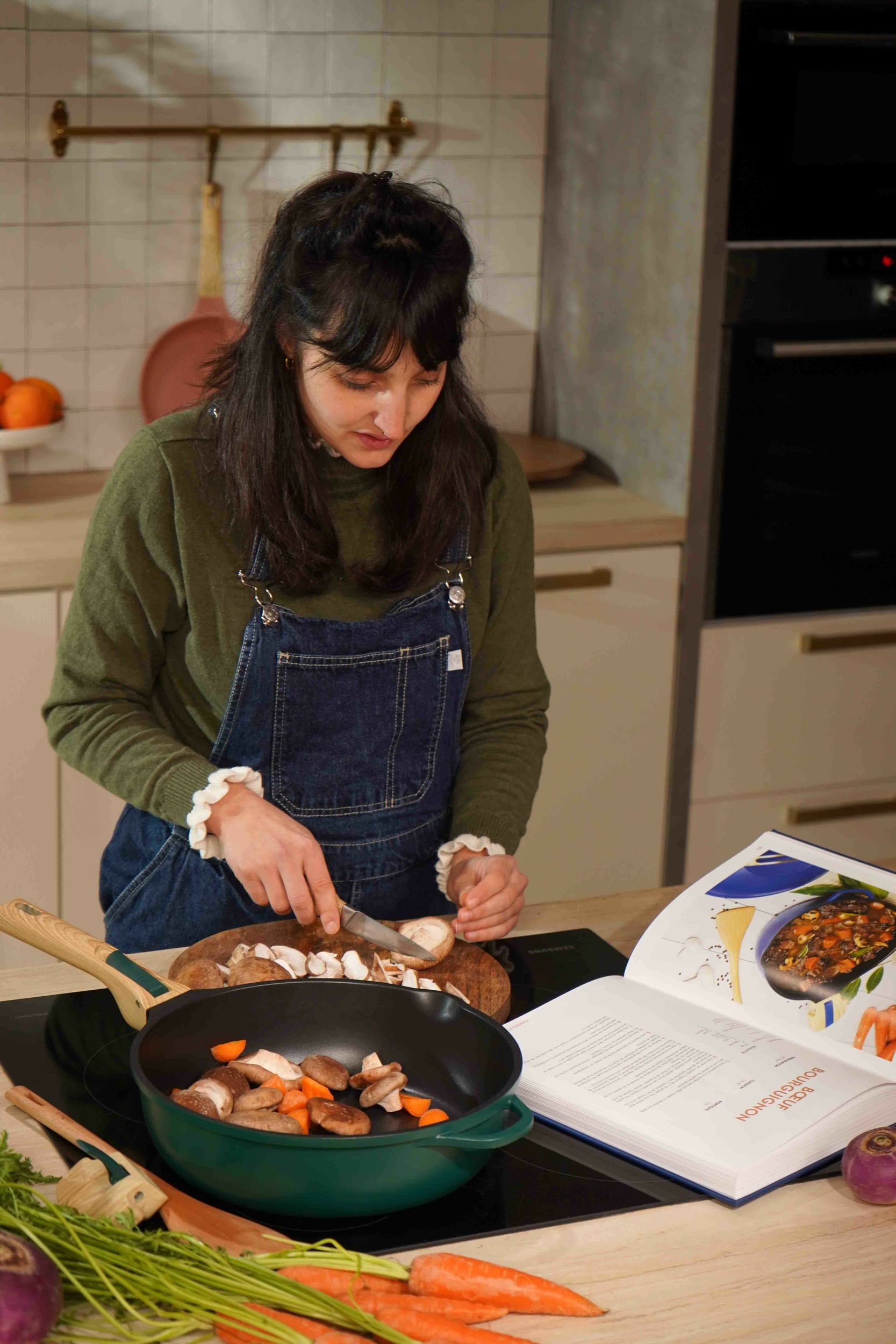Une femme qui cuisine avec un livre de recette