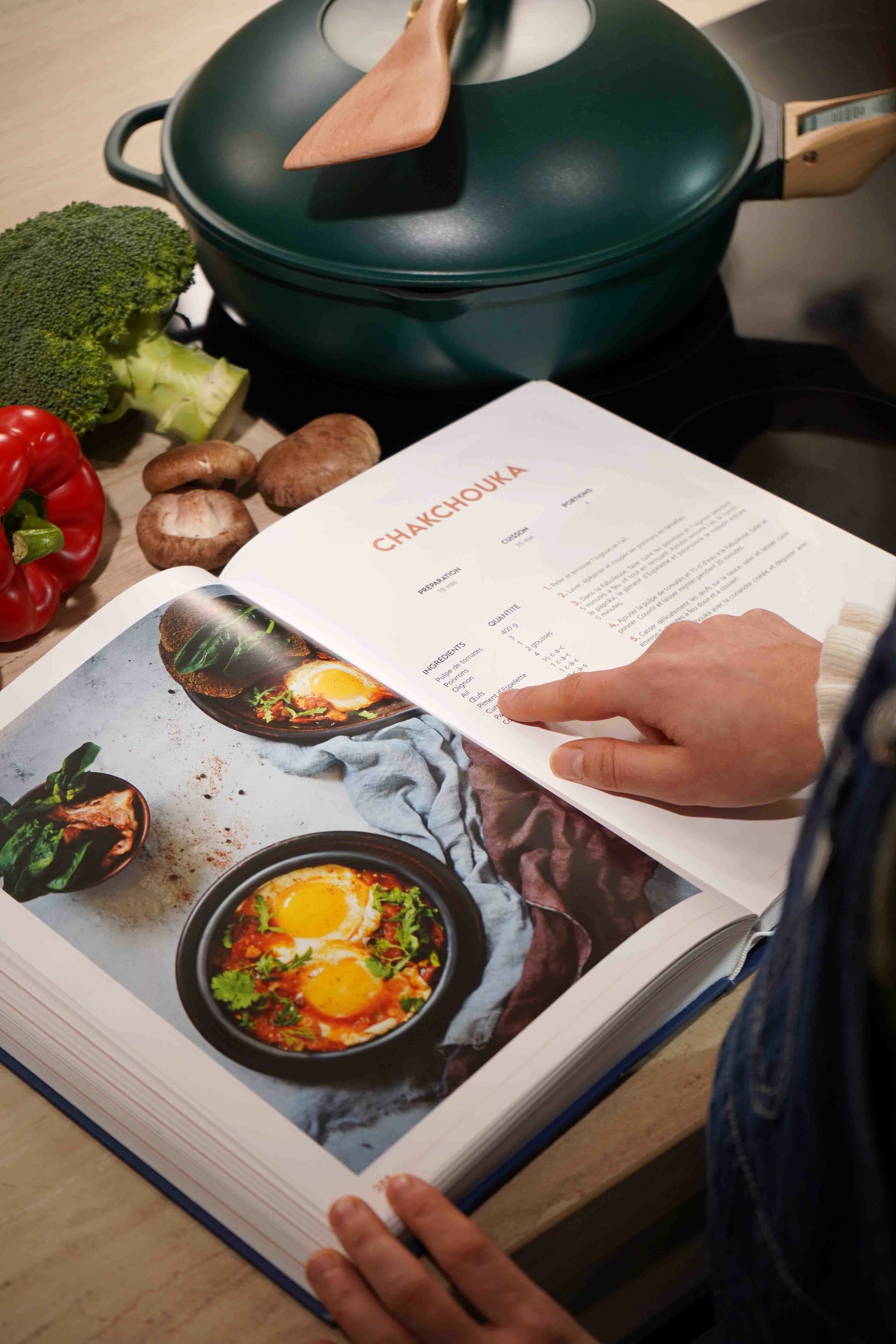 une main qui montre une page sur un livre de 200 recettes pour la fabuleuse