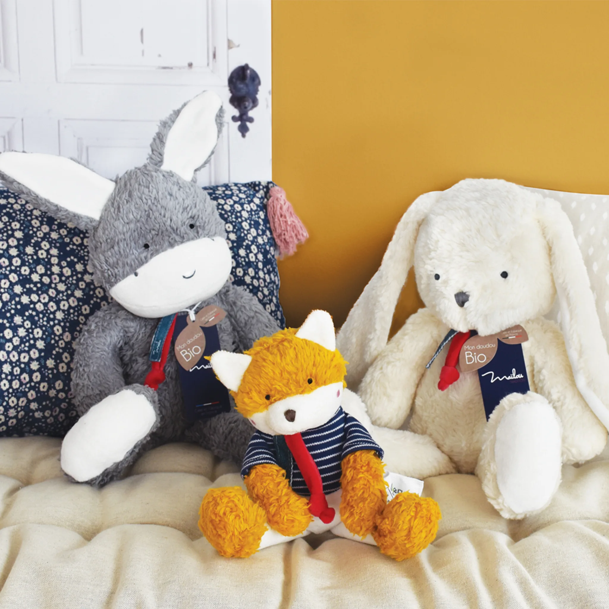 trois peluches sur un lit