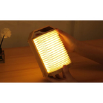 Lampe accordéon allumée entre deux mains