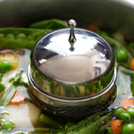 Infuseur flottant à bouquet garni en train de mijoter dans une marmitte pleine de légumes