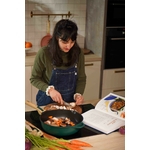 Une femme qui cuisine avec un livre de recette