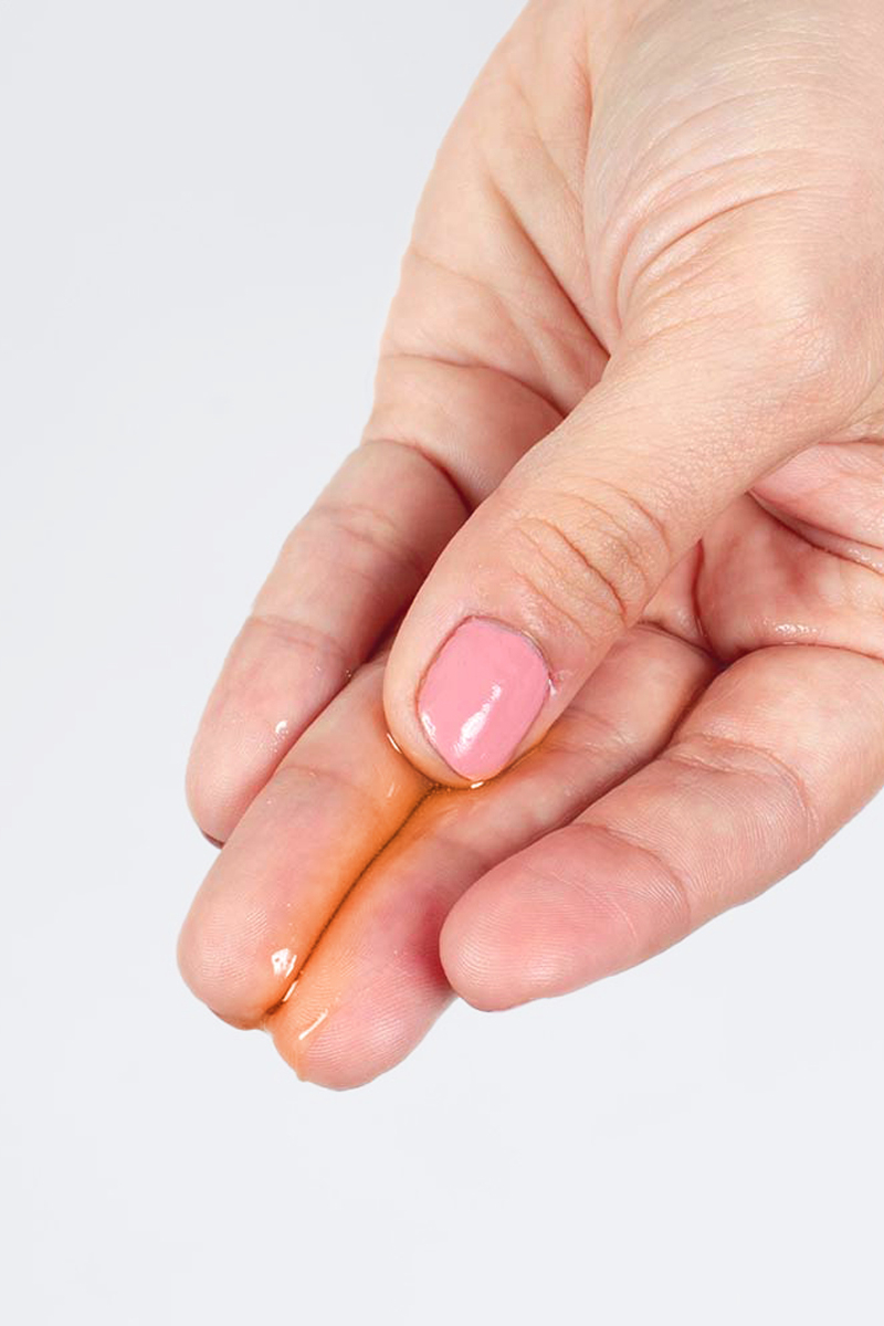 main avec le produit Lubrifiant chauffant goût fruit de la passion Secret Play 50 ml, gel intime 2 en 1 massage et lubrifiant à effet chaud, embrassable et végan, ooh my god