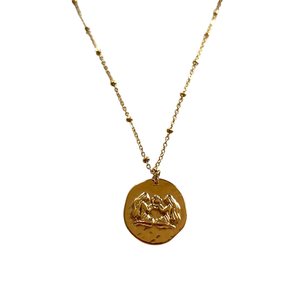 collier medaille relief avec motif representant le signe astrologique gemeaux expose fond blanc