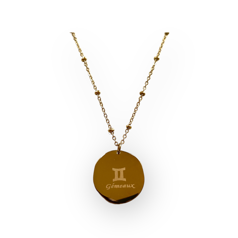 collier medaillon lisse au dos avec le signe astrologique gemeaux ecrit expose fond blanc