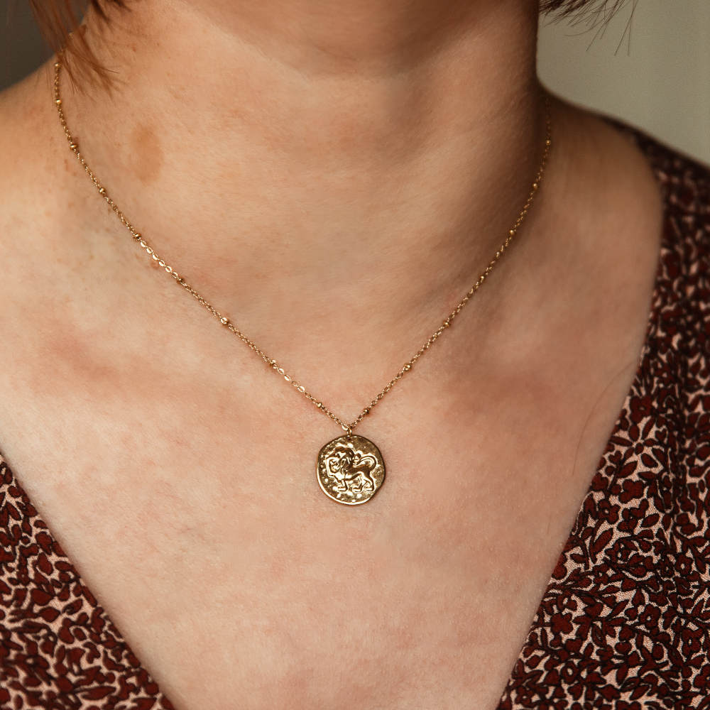 collier pendentif avec medaille frappee avec un lion representant le signe astrologique porte