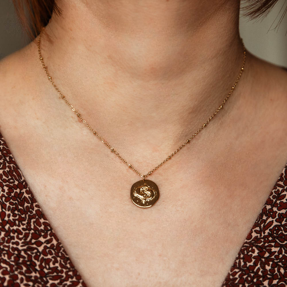 collier pendentif avec medaille motif poisson en relief representant le signe astrologique porte