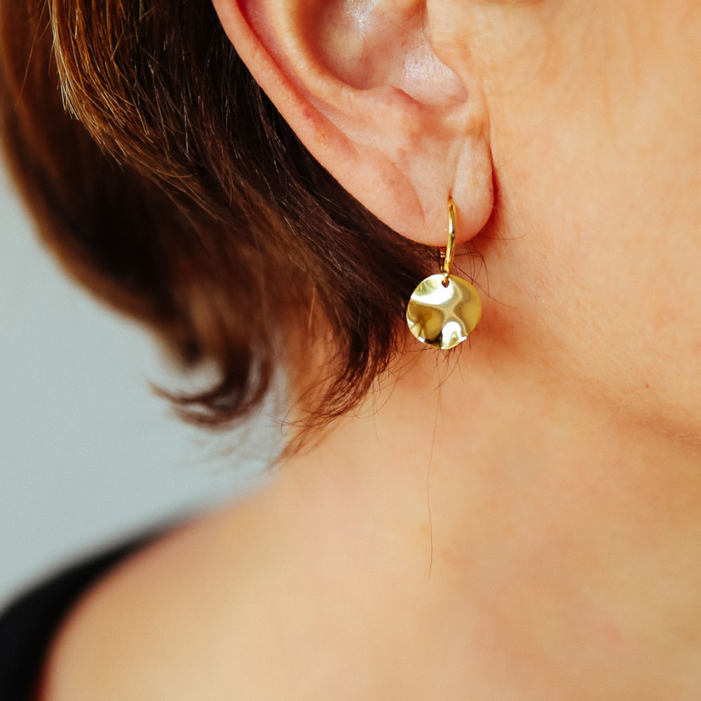 boucles d oreilles plaquees or avec petit anneau et pendentif rond avec surface irreguliere portees oreille droite zoe