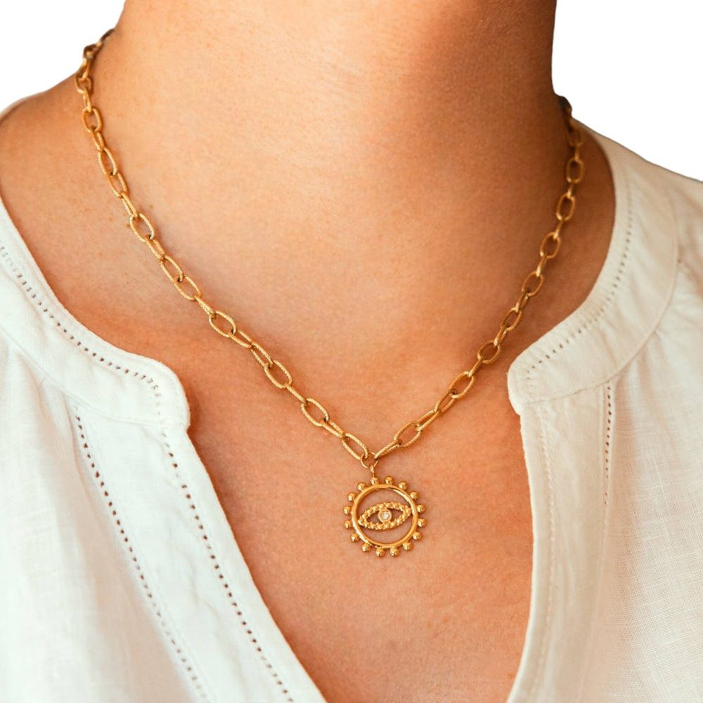 collier oeil chaine maillons pendentif circulaire dore avec un oeil au milieu porte deva