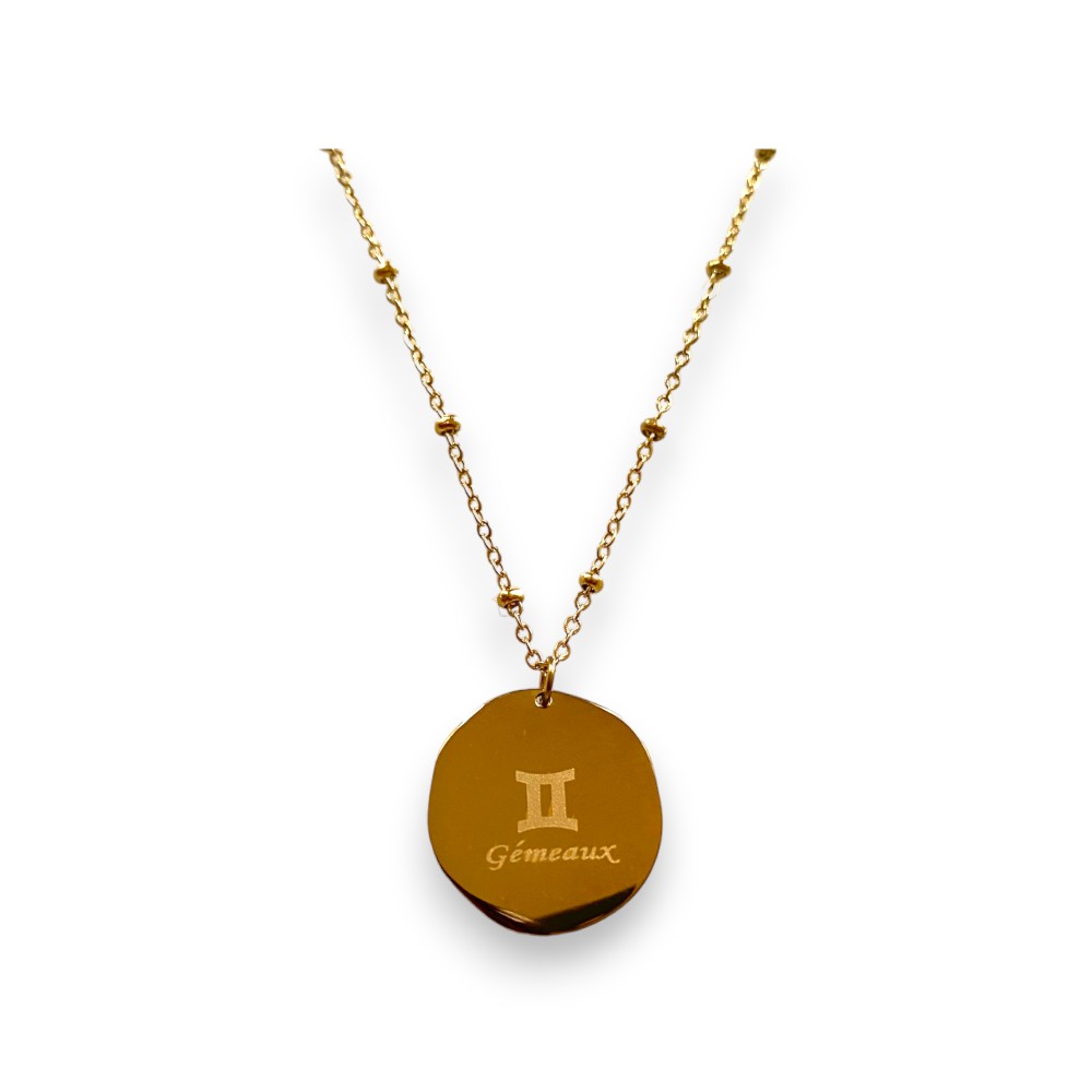 collier medaillon lisse au dos avec le signe astrologique gemeaux ecrit expose fond blanc