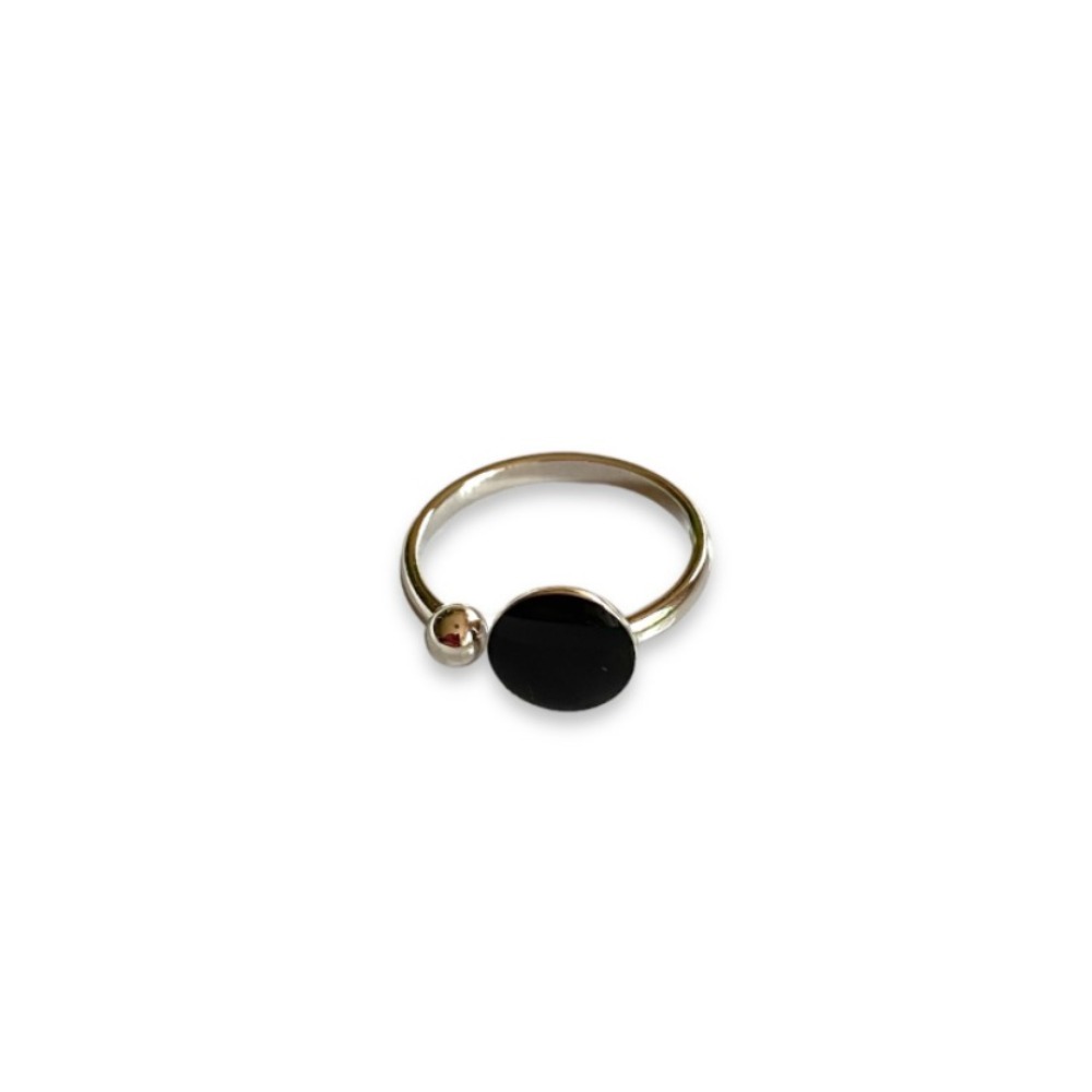 bague ouverte argentee avec forme ronde noire et boule exposee fond blanc anais