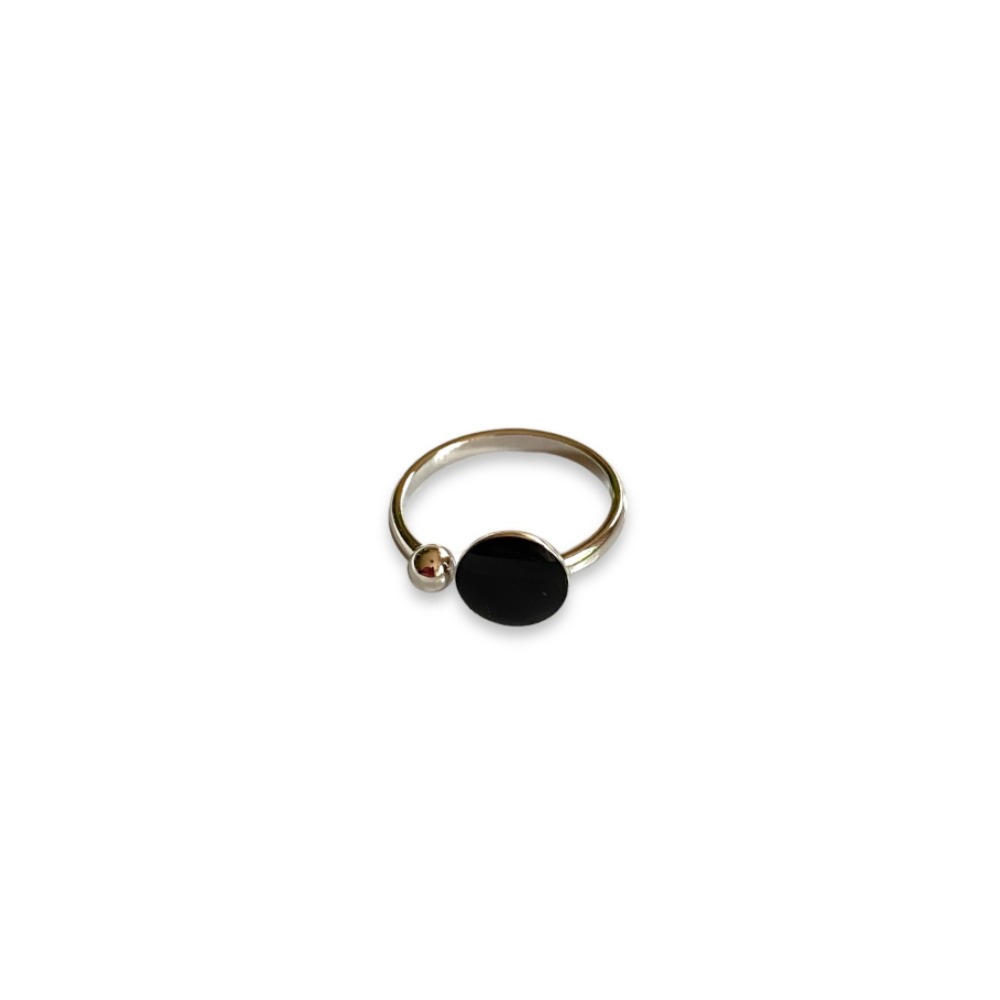 bague ouverte argentee avec forme ronde noire et boule exposee fond blanc anais