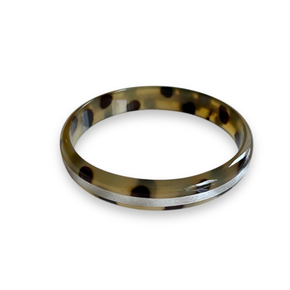bracelet en corne et leopard forme bombee avec ligne argentee expose sur fond blanc leo