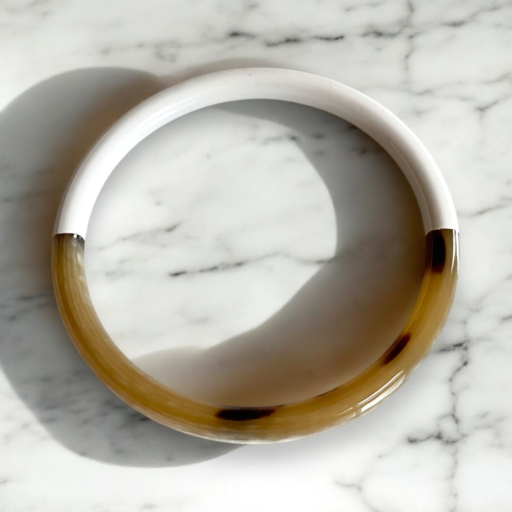 bracelet jonc en corne laquee blanc expose sur fond marbre swann