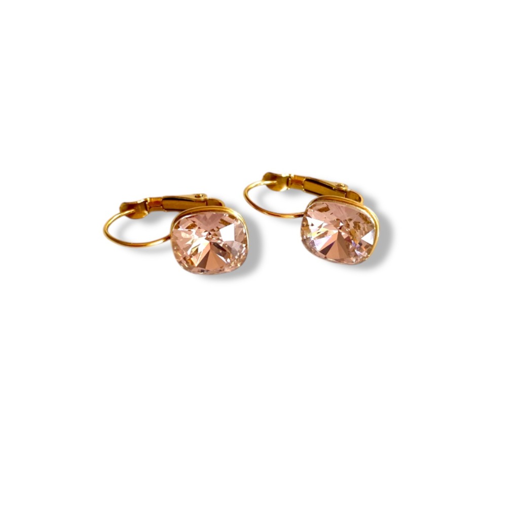 boucle d oreille cristal rose facette avec fermoir dormeuse en acier dore et mis en valeur sur fond blanc cerise