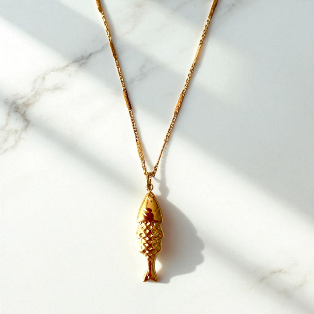 collier poisson en acier dore avec pendentif martele et lisse au verso chaine alternee mis en valeur sur fond en marbre rosalie
