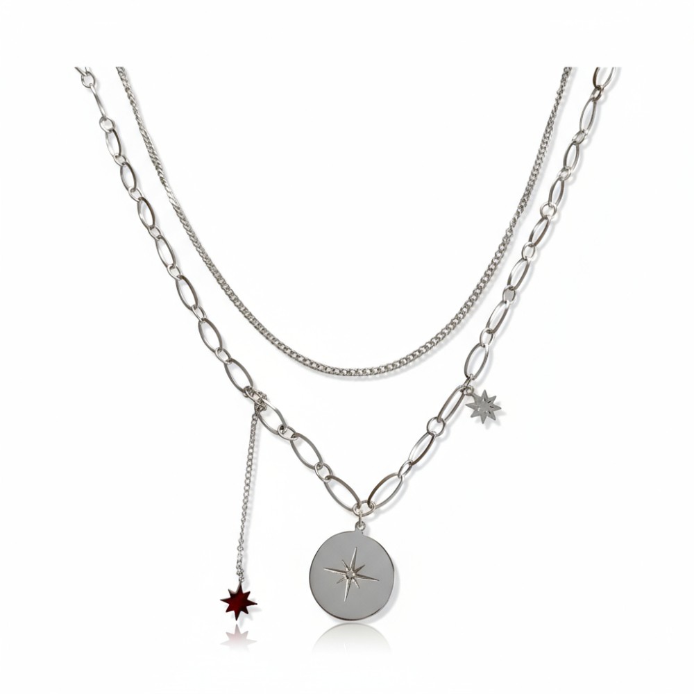collier double rang en acier inoxydable avec une chaine fine et une chaine a maillons plus epais ornee d une  medaille et deux petites étoiles en pendentifs le tout expose sur fond blanc claire