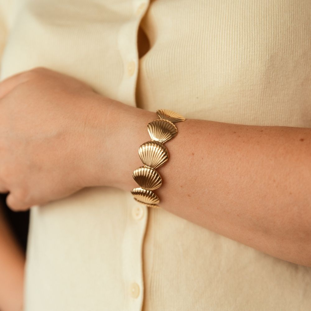 bracelet manchette coquillage Galatée en acier inoxydable doré porté au poignet gauche