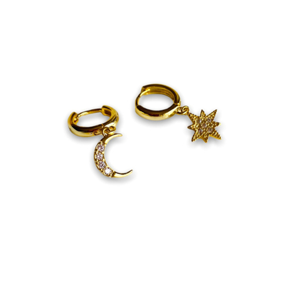 boucles d oreilles asymetriques paire plaquee or anneaux avec pampilles aux motifs differents lune et etoile avec strass exposees fond blanc lucile