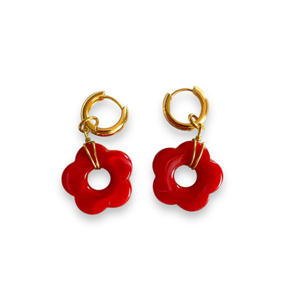 boucles d oreilles creoles pendentif fleur en resine et accroche en acier dore exposees fond blanc elise