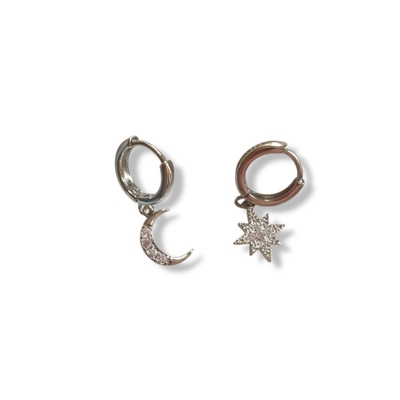 boucle d oreille lune et etoile en plaque argent exposees sur fond blanc avec creoles et pendentifs depareilles ornes de zircons sia