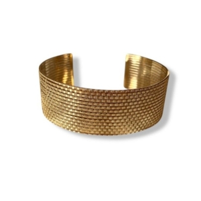 bracelet manchette dore martele et en acier avec motifs points quadrilles expose sur fond blanc solea