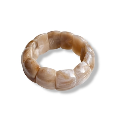 bracelet grosses perles en acetate beige et marbrees sur elastique expose fond blanc elna