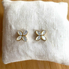 boucles d oreilles trefle 4 feuilles en nacre exposees sur petit coussin blanc solene