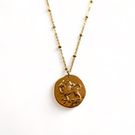 collier pendentif avec medaille frappee avec un lion symbolisant le signe astrologique expose fond blanc