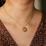 collier pendentif medaillon frappe avec  une balance representant le signe astrologique porte
