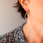 boucles d oreilles geometriques forme en huit argentee portee oreille droite coline