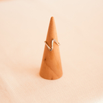 bague ajustable minimaliste ouverte et argentee exposee sur cone bois axelle