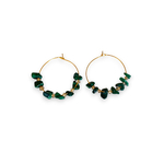boucles d oreilles creoles dorees avec pierres vertes et petites pierres transparentes exposees fond blanc clara