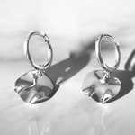 boucles d oreilles petites creoles argent avec pendentif piece texturee de surface inegale exposees fond neutre lucie