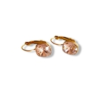 boucle d oreille cristal rose facette avec fermoir dormeuse en acier dore et mis en valeur sur fond blanc cerise
