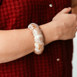 bracelet grosses perles beige en acetate confortable grace a son elastique pour un look estival et moderne et porte sur poignet droit elna