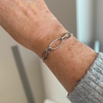 bracelet maillon avec chaine et trois anneaux ovales et lisses en acier inoxydable porte sur poignet droit azalee