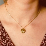 collier pendentif medaillon relief avec animal representant le signe astrologique capricorne porte